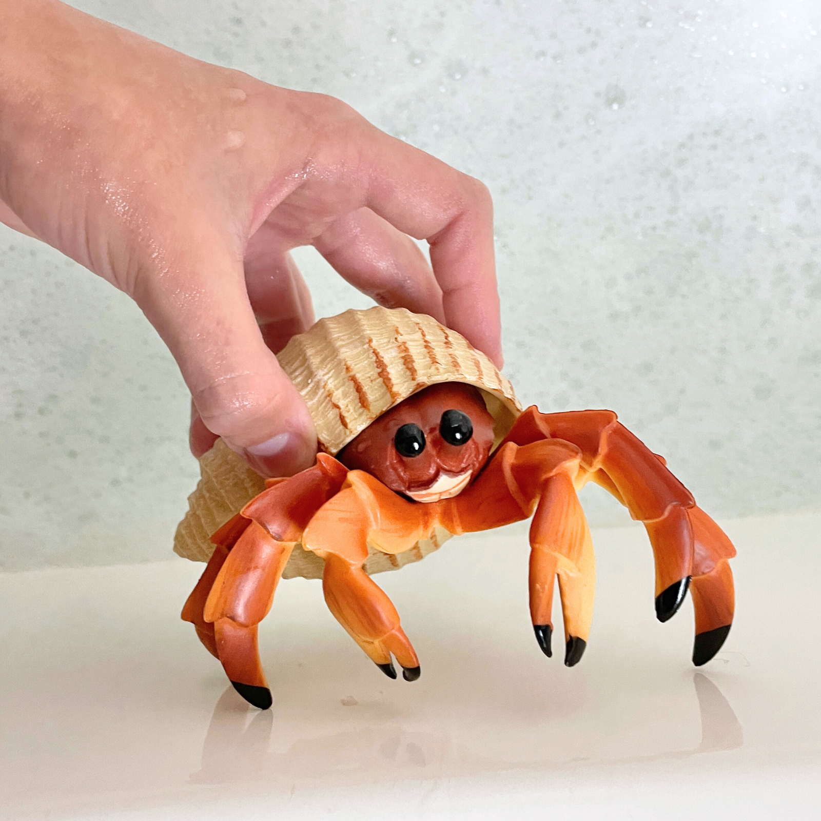 Safari Ltd Hermit Crab figurine held in hand for size reference
