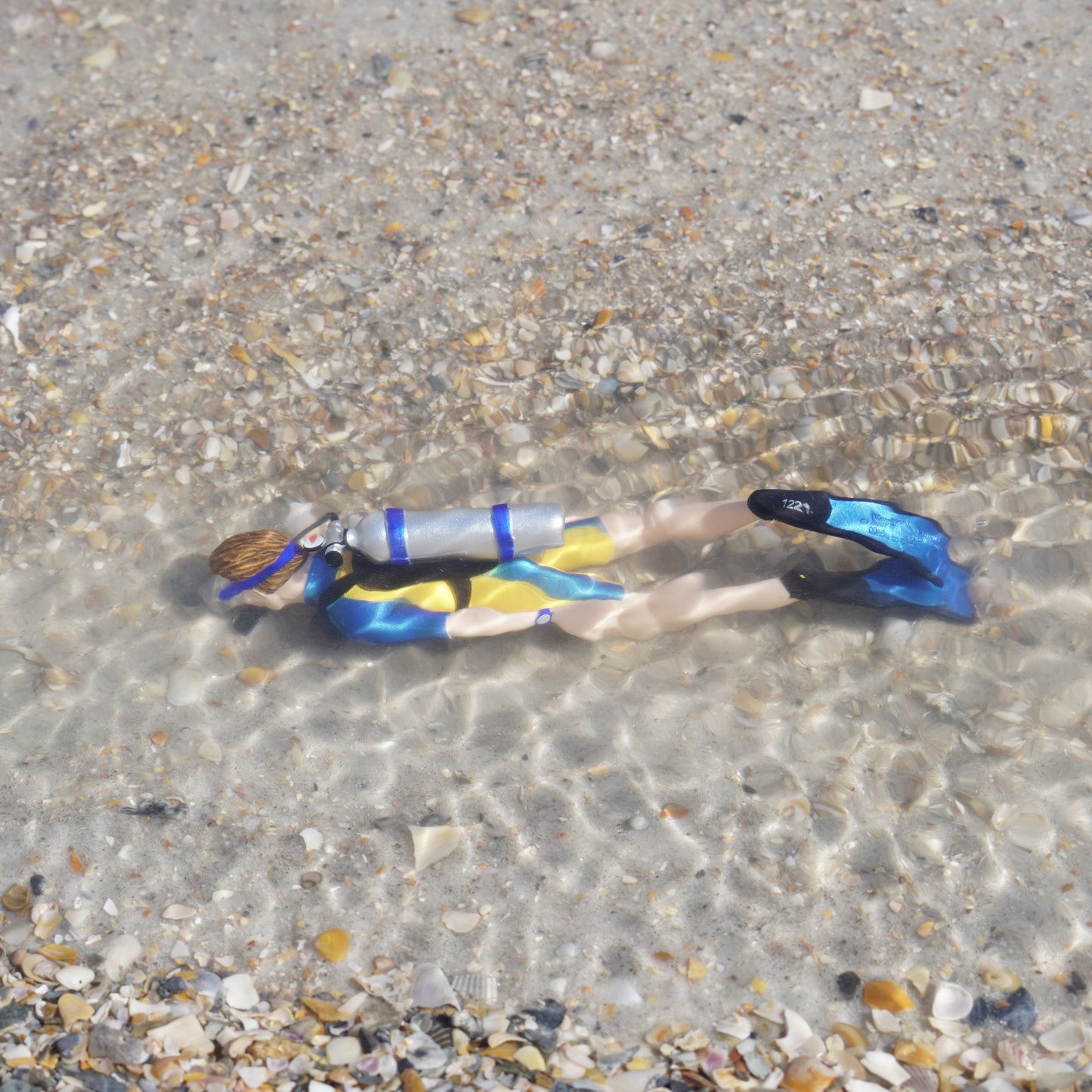 Safari Ltd Kevin scuba diver figurine submerged in shallow ocean water