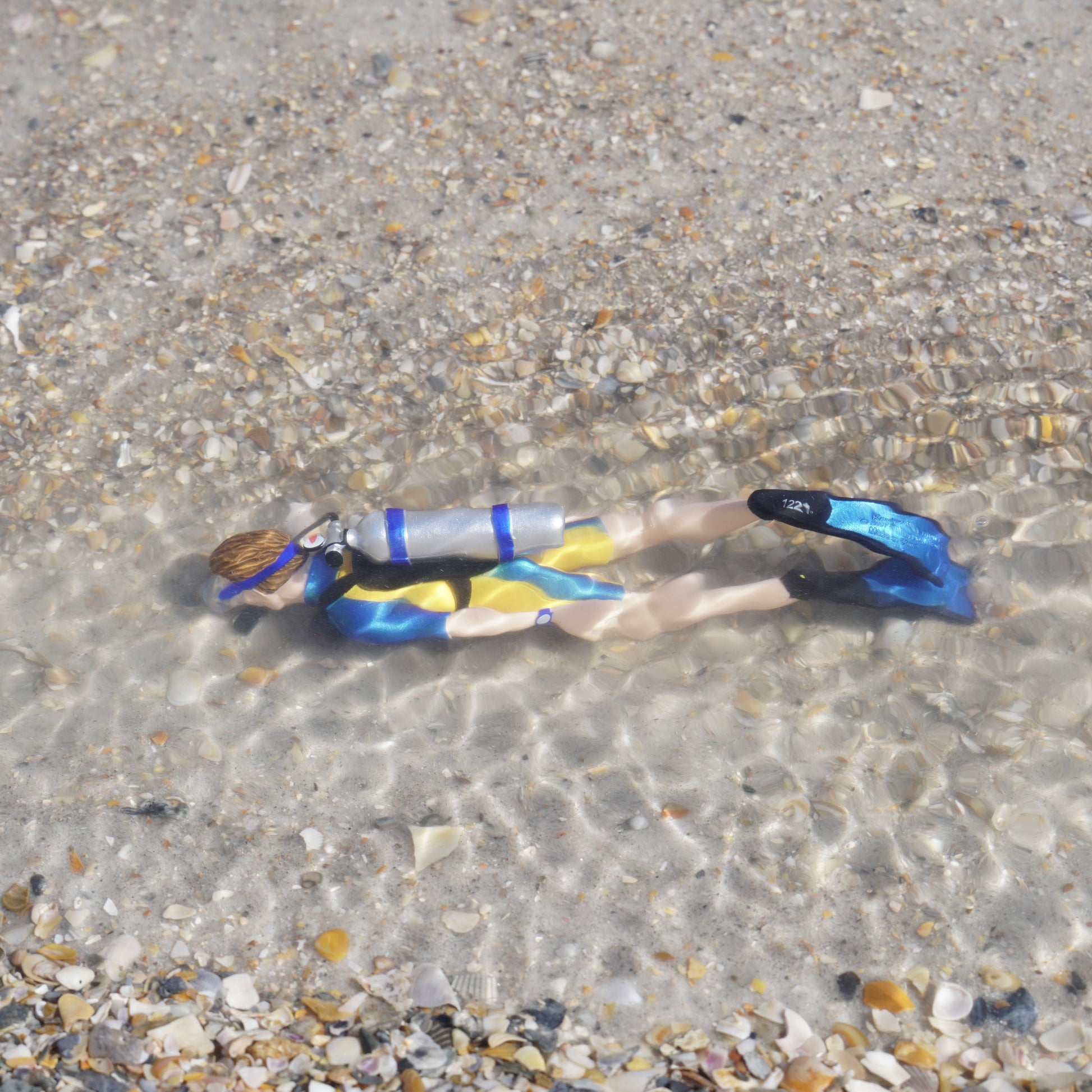 Safari Ltd Kevin scuba diver figurine submerged in shallow ocean water